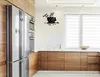 A modern kitchen with wooden cabinets, a stainless steel refrigerator, and a wall clock shaped like a coffee cup. Voir les images du produit