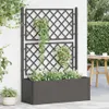 A planter with a trellis and plants on a patio next to a hedge and table. Podgląd zdjęcia produktu