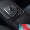 A car's center console with a phone being charged by a coiled USB-C cable plugged into a car charger. Anteprima dell’immagine prodotto