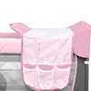 A close-up view of a pink and gray baby travel cot with a mesh organizer attached to the side. Anteprima dell’immagine prodotto