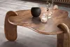 A close-up shot of a wooden coffee table with decorative items on it. Voir les images du produit