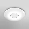 A white, circular ceiling light fixture with a frosted central diffuser, mounted on a light gray ceiling. Produktbild-Vorschau