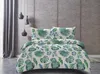 A bed with a duvet cover and pillowcases featuring a green fern pattern, set against a textured wall and grey curtains. Náhled obrázku produktu
