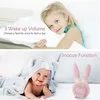 A collage showing a young girl hugging a pillow and a baby wrapped in a blanket next to a pink alarm clock. Produktbild-Vorschau
