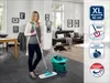 A woman is holding a mop in a modern living room with a sofa and dining table. Anteprima dell’immagine prodotto