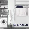 A laundry room scene with a washing machine, shelves with laundry supplies, and a drying rack with towels. Produktbild-Vorschau