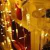 Close-up of Christmas lights shaped like icicles, hanging in front of a fireplace with a stocking. Anteprima dell’immagine prodotto