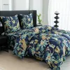 A close-up view of a bed with a duvet cover and pillows featuring a tropical jungle print with leopards. Náhľad obrázku produktu