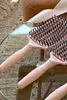 Two pink hairbrushes are placed on a glass table, with a blurred background of a chair and rug. Produktbild-Vorschau