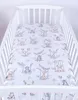 A crib with a fitted sheet featuring a pattern of cartoon animals. Produktbild-Vorschau