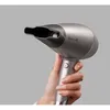 A hand holding a gray Remington hair dryer against a plain gray background. Anteprima dell’immagine prodotto