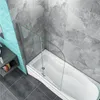 A bathtub with a glass shower screen attached, in a tiled bathroom. Produktbild-Vorschau