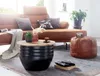A living room scene featuring a couch, coffee table, and ottoman. Voir les images du produit