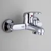 A chrome-finished bathroom faucet mounted on a light gray wall. Podgląd zdjęcia produktu