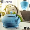 A light blue cast iron teapot and cup are displayed on a table with dimensions indicated by lines and text. Náhled obrázku produktu