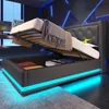 A modern bedroom with a bed that has its storage compartment open, revealing items inside. The bed has LED lighting around its base. Produktbild-Vorschau