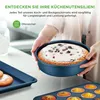 A person is holding a round cake pan with a cake in it, with other baking pans visible in the foreground. Produktbild-Vorschau