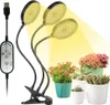 A plant grow light with three adjustable heads is shown clipped to a stand, illuminating several potted plants. Anteprima dell’immagine prodotto
