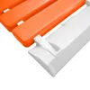 Close-up view of a folding shower seat, showing the connection between the orange seat and the white wall-mounted bracket. Náhled obrázku produktu