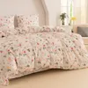 A neatly made bed with floral and bunny patterned bedding. Produktbild-Vorschau