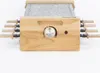 A close-up, front-facing view of a raclette grill with a granite stone cooking surface and wooden handles. Produktbild-Vorschau