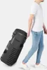 A person is pulling a large black speaker with wheels. Produktbild-Vorschau