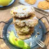A stack of apple scones dusted with powdered sugar, served on a dark plate with apple slices and mint. Produktbild-Vorschau