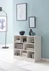 A white bookshelf filled with books and decorative items, placed against a light blue wall. Produktbild-Vorschau