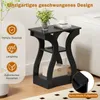 A black side table with decorative curved legs and two shelves, placed in a room setting next to a white sofa. A vase of flowers and a book with a cup of coffee are on the top shelf. Produktbild-Vorschau