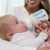 A person is feeding a baby with a bottle. Produktbild-Vorschau