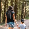 A woman and a child walking on a path in a forest. Produktbild-Vorschau