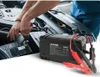 A person is working on a car engine, with a jump starter battery in the foreground. Náhled obrázku produktu