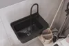 A black sink with a black faucet is shown in a utility room setting, with cleaning supplies nearby. Anteprima dell’immagine prodotto