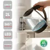 A hand is pouring water from a glass electric kettle into a white mug. The background shows a kitchen setting. Produktbild-Vorschau