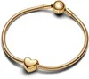 A close-up studio shot of a gold Pandora bracelet with a heart-shaped charm and a clasp with the Pandora logo. Podgląd zdjęcia produktu