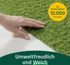 A hand touching artificial grass with a promotional overlay. Náhled obrázku produktu