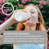 A young girl drinks from a bottle in an outdoor setting with flowers in the background. Produktbild-Vorschau