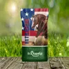A bag of horse feed is placed on a wooden surface with a background of green grass and blurred lights. Produktbild-Vorschau