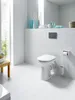 A clean, modern bathroom with white tiled walls and floor, featuring a white toilet. Produktbild-Vorschau