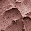 A close-up texture shot of a pink cosmetic product with dark particles. Produktbild-Vorschau