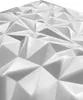 A close-up, angled view of a white, textured surface composed of geometric triangular facets, resembling a 3D wall panel. Produktbild-Vorschau