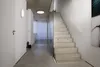 A modern interior hallway with a concrete staircase and glass partition. Produktbild-Vorschau