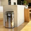 A modern kitchen with a stainless steel trash can next to a marble island. Anteprima dell’immagine prodotto