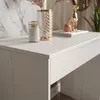 A close-up view of a white console table with decorative items on top. Náhled obrázku produktu