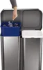 A person is using tongs to place a plastic bottle into a blue bin inside a dual-compartment trash can. Podgląd zdjęcia produktu