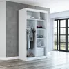 A white wardrobe with sliding doors is shown in a room with a concrete wall and wooden floor. Produktbild-Vorschau
