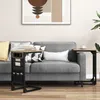 A living room scene with a gray sofa and two C-shaped side tables, one with integrated charging ports and storage. Produktbild-Vorschau