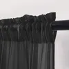 A close-up view of a black sheer curtain hanging on a dark curtain rod. Produktbild-Vorschau