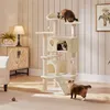 A multi-level cat tree with three cats interacting with it in a living room setting. Podgląd zdjęcia produktu