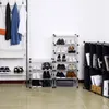 A collection of shoe racks and clothing on hangers in a room. Produktbild-Vorschau